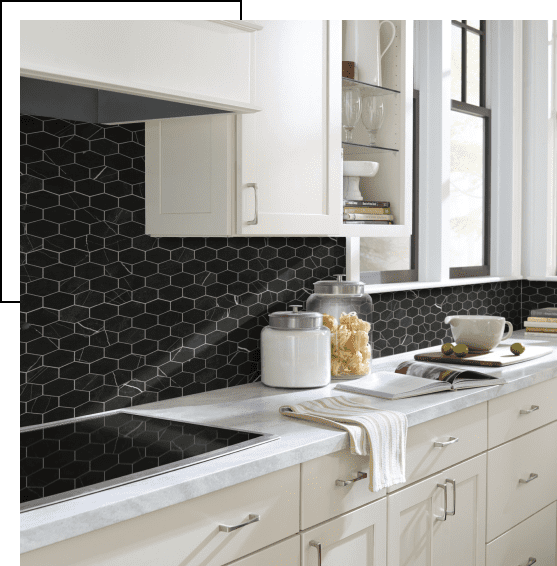Modern kitchen with white cabinets and black hexagonal tile backsplash.