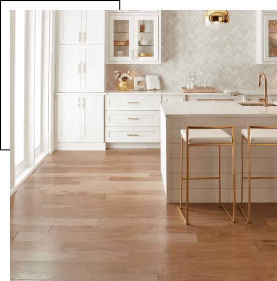 Bright modern kitchen with white cabinets and wooden floor.