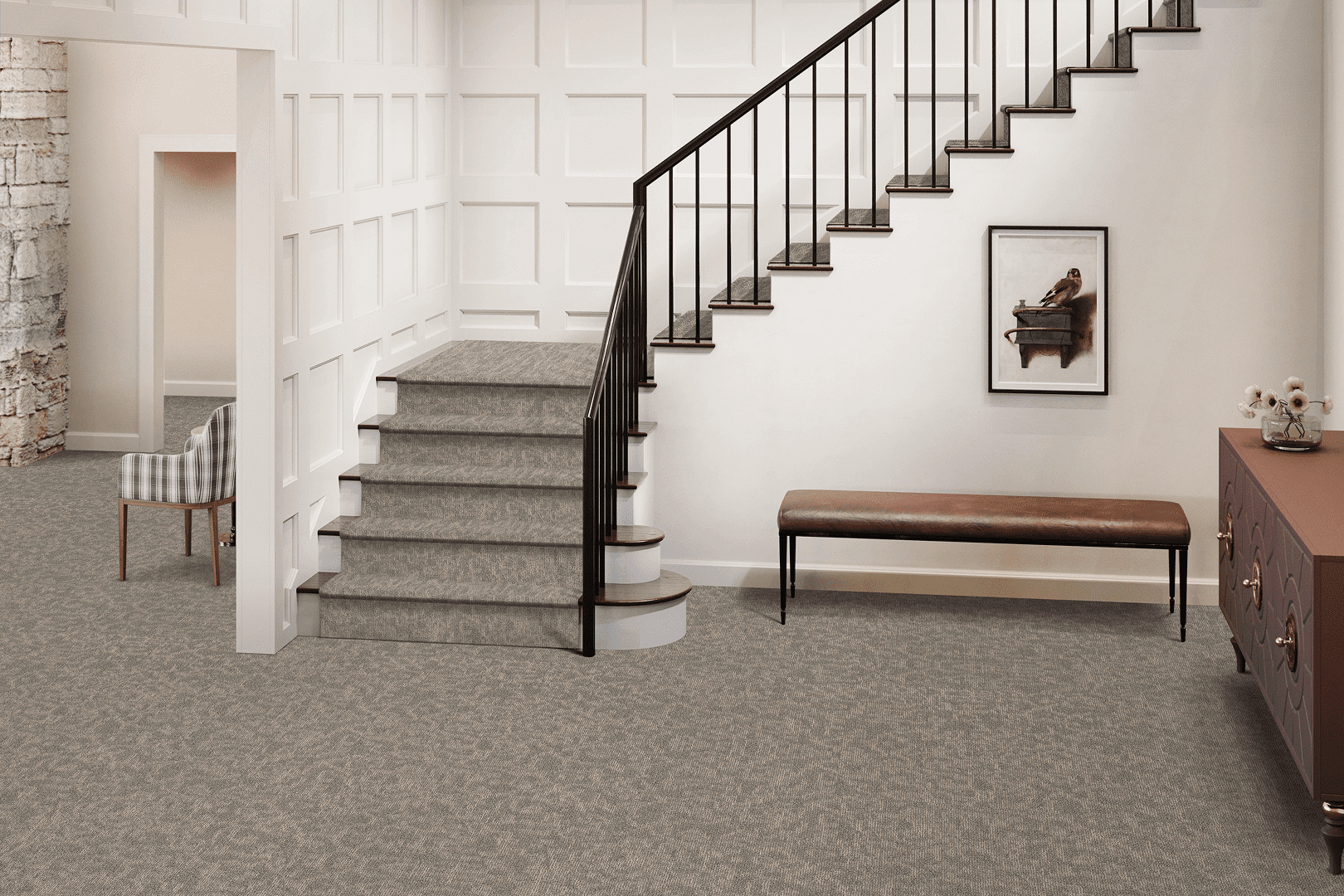 A carpeted staircase with a wooden handrail and a bench nearby.