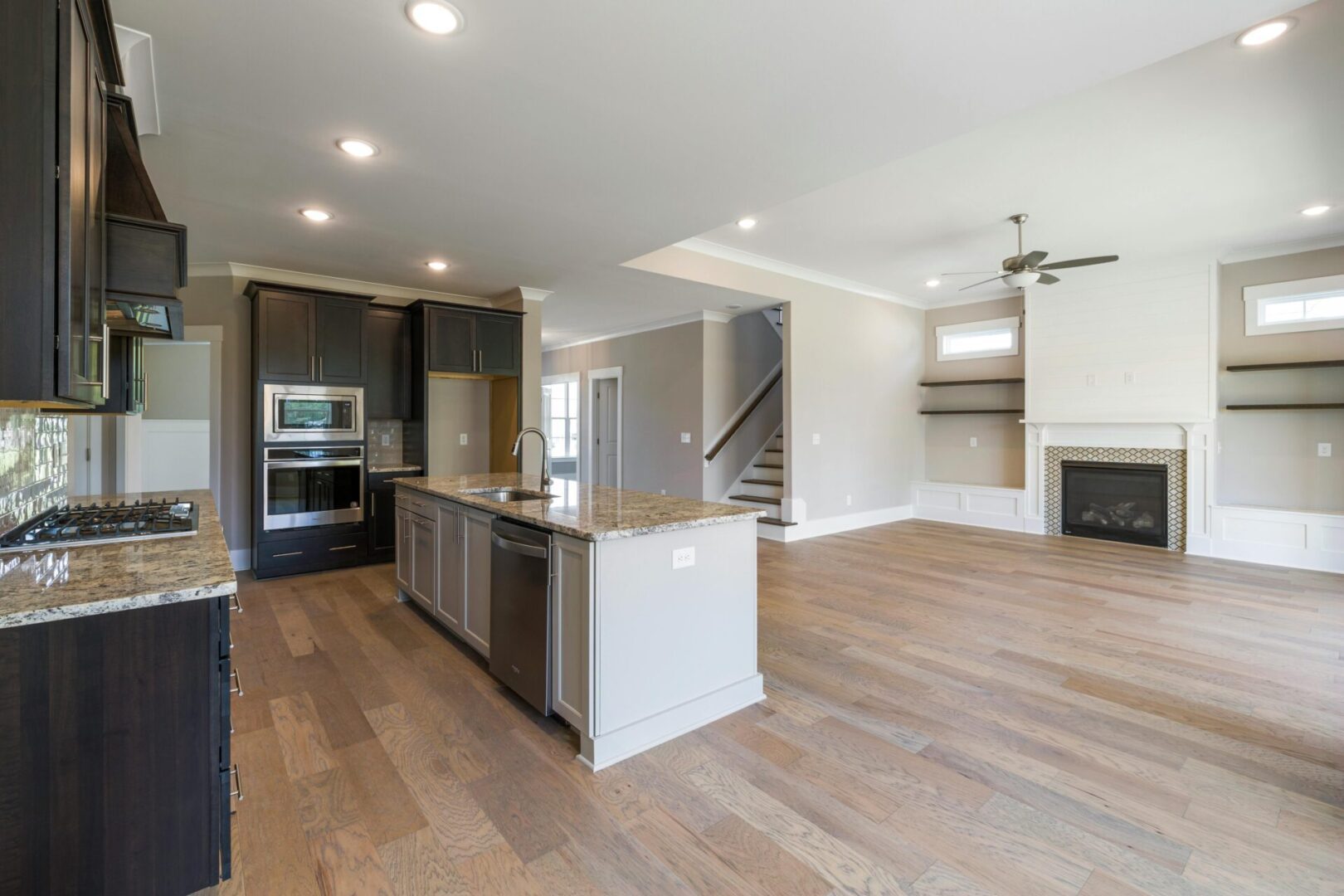 Modern open-concept kitchen and living area with hardwood floors.