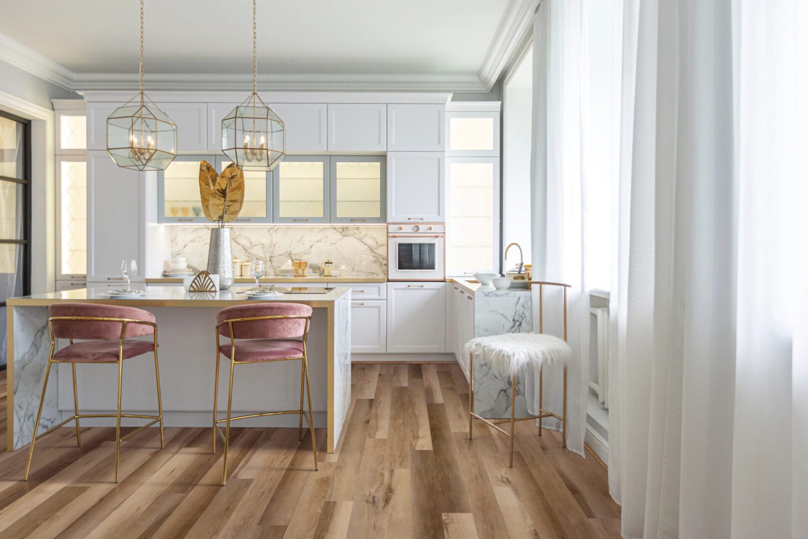 Bright modern kitchen with white cabinets and wooden floor.