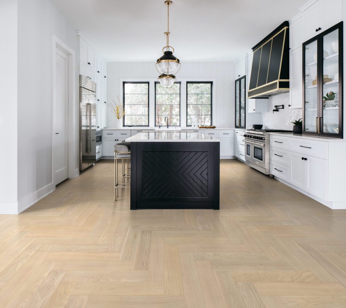 Modern kitchen with black island and white cabinetry.